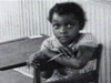 A young African American child in a 1950s classroom