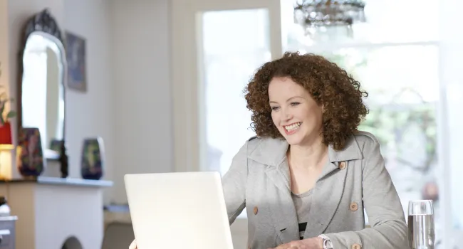 Woman working on laptop and smiling